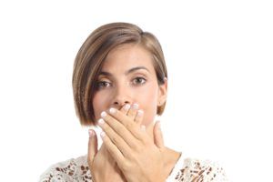 woman covering her mouth in embarrassment 